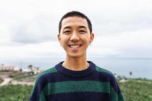 ritratto di contento giovane asiatico adolescente sorridente nel davanti di telecamera foto