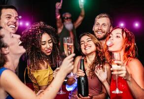 contento amici fabbricazione festa potabile Champagne nel il discoteca - giovane persone avendo divertimento festeggiare e danza nel il discoteca club - vita notturna, divertimento e gioventù stile di vita vacanze foto