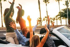 contento amici avendo divertimento nel convertibile auto nel vacanza - giovane persone godendo tempo in viaggio e danza nel un' cabrio auto durante loro strada viaggio - amicizia, viaggiare, gioventù stile di vita concetto foto