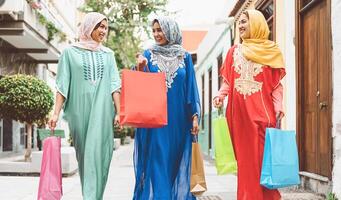 contento musulmano donne fare shopping nel il città centro - arabo adolescente ragazze avendo divertimento acquisto nuovo tradizionale arabo Abiti nel centro commerciale - concetto di persone religione, acquirente, consumismo e diverso cultura foto