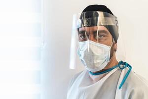 medico indossare ppe viso chirurgico maschera e visiera combattente contro corona virus scoppio - Salute cura e medico lavoratori concetto foto