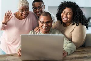 contento nero famiglia avendo divertimento fare video chiamata utilizzando il computer portatile a casa durante corona virus scoppio - tecnologia e comunicazione concetto foto