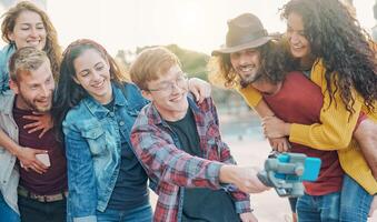 contento di moda amici fabbricazione video con gimbal smartphone telecamera nel il città - del Millennio giovane persone avendo divertimento con nuovo tecnologia per sociale media Rete all'aperto - Tech e gioventù stile di vita concetto foto