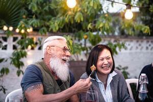 contento anziano amici avendo divertimento a cena Casa festa - anziano stile di vita persone e cibo concetto foto