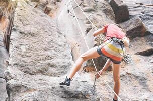 atletico forte uomo arrampicarsi un' roccia parete - scalatore l'esecuzione su un' canyon montagna - concetto di estremo sport, stile di vita viaggio e adrenalina foto