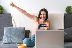 giovane donna giocando in linea video Giochi - contento gamer avendo divertimento su nuovo tecnologia consolle - gioco divertimento e gioventù del Millennio generazione stile di vita concetto foto