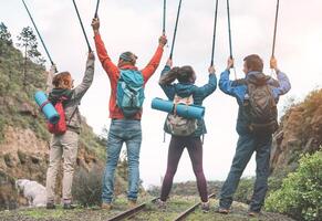 gruppo di amici raccolta mani su Tenere il trekking poli su un' picco di montagna - giovane persone esplorando il natura - concetto di escursione, viaggio e alpinismo foto