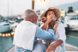 anziano coppia Data potabile Champagne su barca a vela vacanza - contento anziano persone avendo divertimento festeggiare nozze anniversario su barca viaggio - relazione amore e romantico viaggio incontri concetto foto