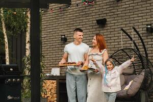 un' contento famiglia ha preparato pranzo e volontà mangiare a loro Casa. ritratto di un' famiglia con cibo nel loro mani foto