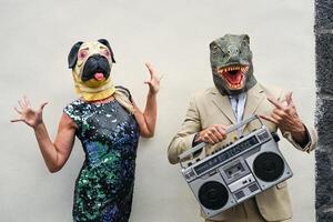 contento anziano coppia avendo divertimento indossare cane e t-rex maschera - maturo persone festeggiare carnevale vacanze mentre danza e ascoltando musica con Vintage ▾ Boombox stereo foto