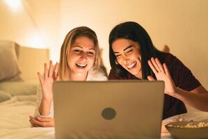 giovane donne utilizzando il computer portatile nel letto durante corona virus scoppio foto