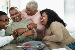 contento africano famiglia avendo divertimento dopo un' pranzo insieme a casa - cibo e genitori unità concetto foto