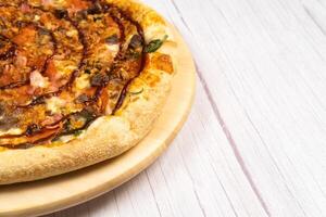 delizioso grande Pizza con Bacon e spinaci su un' leggero di legno sfondo foto