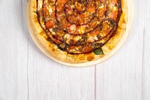 delizioso grande Pizza con Bacon e spinaci su un' leggero di legno sfondo foto