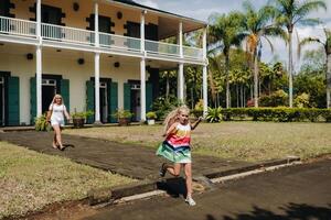 un' poco ragazza con sua madre corre in giro il botanico giardino su il Paradiso isola di mauritius foto