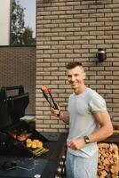 un' uomo su il strada è cucinando un' bistecca su il griglia a un' barbecue foto