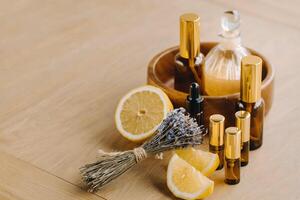 essenziale olio nel bottiglie con Limone e lavanda fragranza, dire bugie su un' di legno superficie foto
