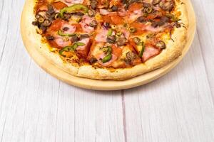 delizioso grande Pizza con vitello e funghi su un' leggero di legno sfondo foto
