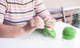 avvicinamento di donna mano maglieria con verde lana foto