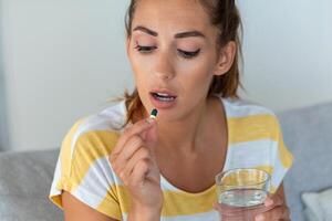 donna prende medicinali con bicchiere di acqua. quotidiano norma di vitamine, efficace droghe, moderno farmacia per corpo e mentale Salute concetto foto