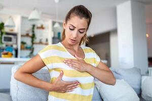 giovane caucasico donna palpando sua Seno di se stessa quello lei preoccupazione di Seno cancro. assistenza sanitaria e Seno cancro concetto foto