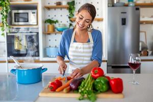 bellissimo giovane donna In piedi a moderno cucina chop verdure preparare fresco verdura insalata per cena o il pranzo, giovane donna cucinando a casa rendere prima colazione Seguire salutare dieta, vegetariano concetto foto