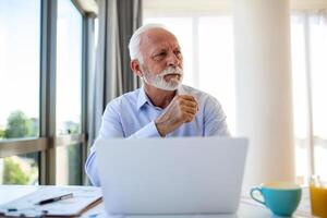 finanziario consulente uomo d'affari utilizzando il suo il computer portatile e fare alcuni lavoro d'ufficio mentre seduta a scrivania e Lavorando. foto