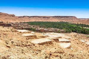 un' villaggio a un oasi a il parte inferiore di un' canyon nel il atlante montagne, Marocco foto