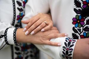 il sposa e sposo siamo Tenere mani con un' mazzo di fiori e nel tradizionale ucraino Abiti foto