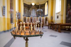 candele bruciare meravigliosamente su un' In piedi nel il Chiesa foto