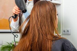 ritratto di un' bellissimo donna con lungo Marrone dritto capelli nel un' bellezza salone. foto