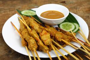 indulgere nel il bellezza di bellissimo satay, dove spiedini di marinato diletto siamo alla brace per d'oro perfezione, offerta un' sinfonia di gusto nel ogni mordere, un' culinario abilità artistica per assaporare foto