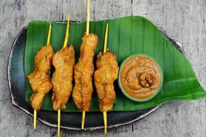 indulgere nel il bellezza di bellissimo satay, dove spiedini di marinato diletto siamo alla brace per d'oro perfezione, offerta un' sinfonia di gusto nel ogni mordere, un' culinario abilità artistica per assaporare foto