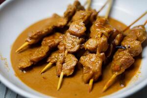 indulgere nel il bellezza di bellissimo satay, dove spiedini di marinato diletto siamo alla brace per d'oro perfezione, offerta un' sinfonia di gusto nel ogni mordere, un' culinario abilità artistica per assaporare foto