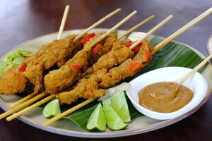 indulgere nel il bellezza di bellissimo satay, dove spiedini di marinato diletto siamo alla brace per d'oro perfezione, offerta un' sinfonia di gusto nel ogni mordere, un' culinario abilità artistica per assaporare foto