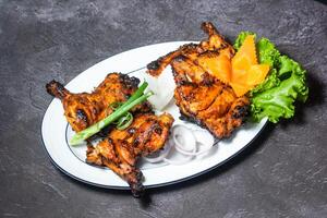 tandoori pollo con cipolla e insalata servito nel piatto isolato su grigio sfondo superiore Visualizza di indiano e bangladesh cibo foto