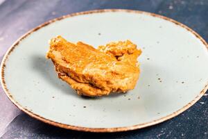 croccante fritte pollo pezzo nel un' piatto isolato su marmo sfondo superiore Visualizza veloce cibo foto