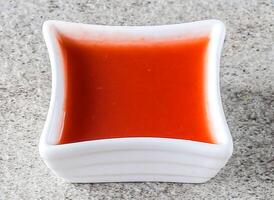 speziato chili salsa servito nel pentola superiore Visualizza su sfondo foto