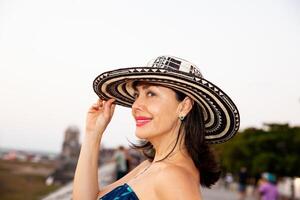 bellissimo donna indossare il tradizionale colombiano cappello chiamato sombrero vueltiao a il storico strade di il cartagena de indie murato città foto