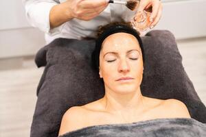 senza volto cosmetologo fare viso trattamento per donna nel salone foto