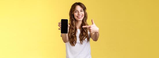 ottimista fiducioso bella vista femmina mostrando foto smartphone Schermo hold mobile Telefono esteso braccio telecamera puntamento indice dito cellulare schermo sorridente Contentissimo promuovere App Internet applicazione