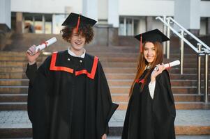 ritratto di Due contento laurea studenti. foto