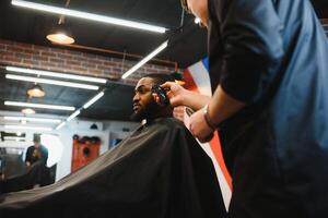 africano maschio cliente ottenere taglio di capelli a barbiere negozio a partire dal professionale parrucchiere. foto