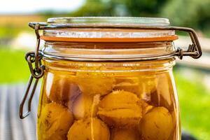 sterilizzato mirabelle prugne, fatti in casa frutta nel sciroppo per il inverno, conserve nutrienti foto