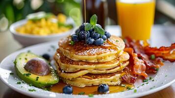 ai generato buongustaio prima colazione diffusione Pancakes, avocado, uova, Bacon, e Di Più foto