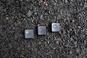 il parola correre scritto nel nero tastiera chiavi su il asfalto sfondo foto