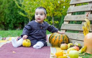 il poco bambino giocando nel il parco con frutta, poco ragazza nel il autunno parco foto