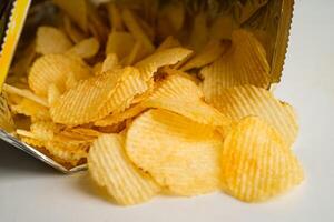 patatine, delizioso condimento per barbecue piccante per patatine fritte, spuntino fritto a fettine sottili in sacchetto aperto. foto