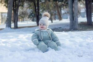 bambino nel inverno, il bambino posa su il neve foto