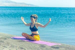 persona fare yoga esercizio su il spiaggia, persona rilassante su il spiaggia, personn fare yoga foto